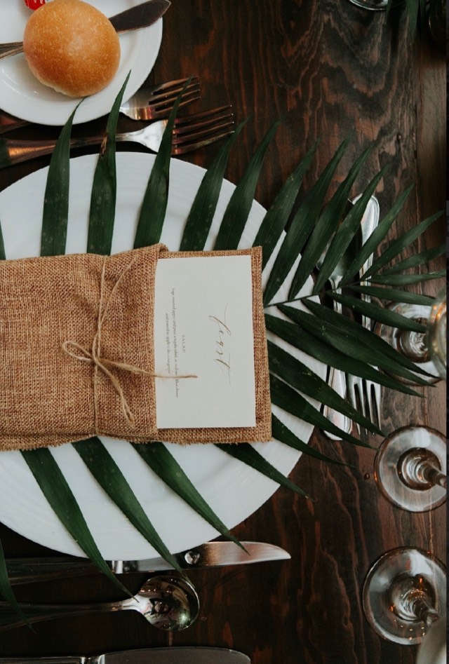 Coastal Celebrations event — tropical floral arrangements with lush palm greenery in a warm candlelit venue, image 2 of 7 — Lux Events by Michelle