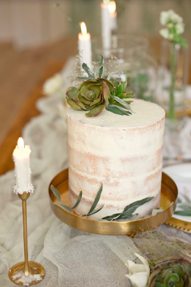 Desert Reverie wedding cake — naked cake with succulent topper on a gold stand beside ivory taper candles — Lux Events by Michelle