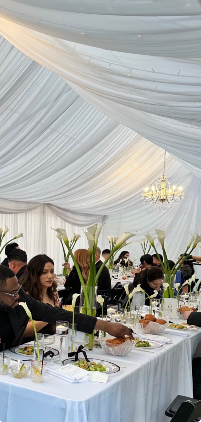 Minimalist luxury wedding reception — white draped tent with crystal chandelier and calla lily centerpieces, guests in formal attire — Lux Events by Michelle